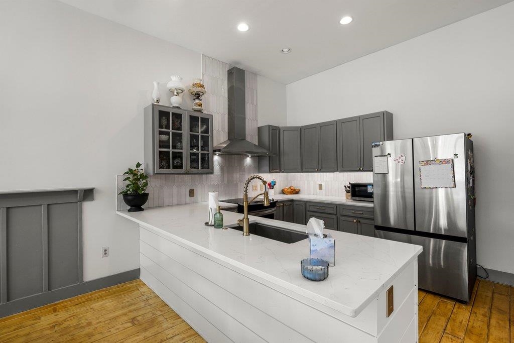 403 West Main Street Llano, TX 78643 - Photo 4 of 28 a kitchen with stainless steel appliances a sink dishwasher and a refrigerator with wooden floor