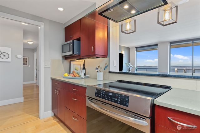 a kitchen with stainless steel appliances granite countertop a stove a sink and a microwave