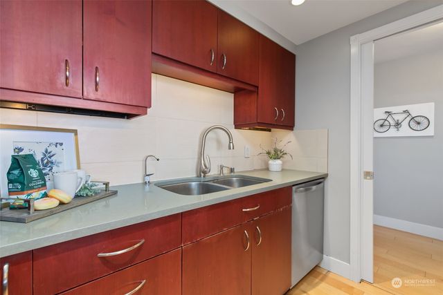 a kitchen with stainless steel appliances granite countertop a sink a stove and cabinets