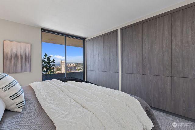 a bedroom with a large bed and a potted plant