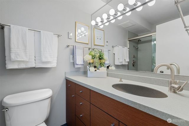 a bathroom with a granite countertop sink a toilet and a mirror