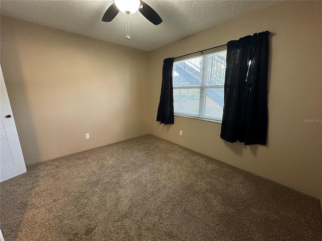 2440 Enterprise Road, Unit 2 Clearwater, FL 33763 - Photo 13 of 19 an empty room with ceiling fan and window