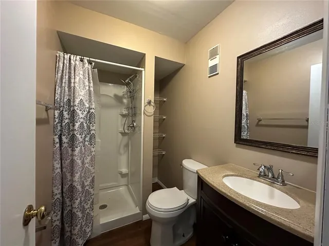 a bathroom with a granite countertop toilet sink and shower