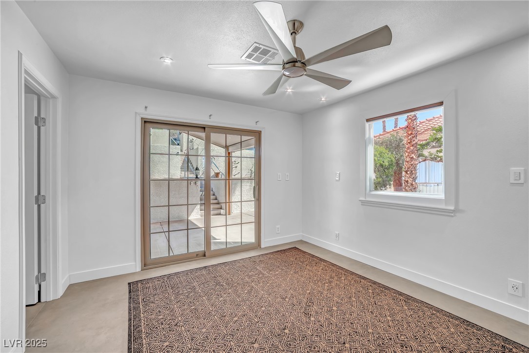 1318 Denver Street Boulder City, NV 89005 - Photo 17 of 32 Primary bedroom with plenty of natural light, slider to patio and a ceiling fan