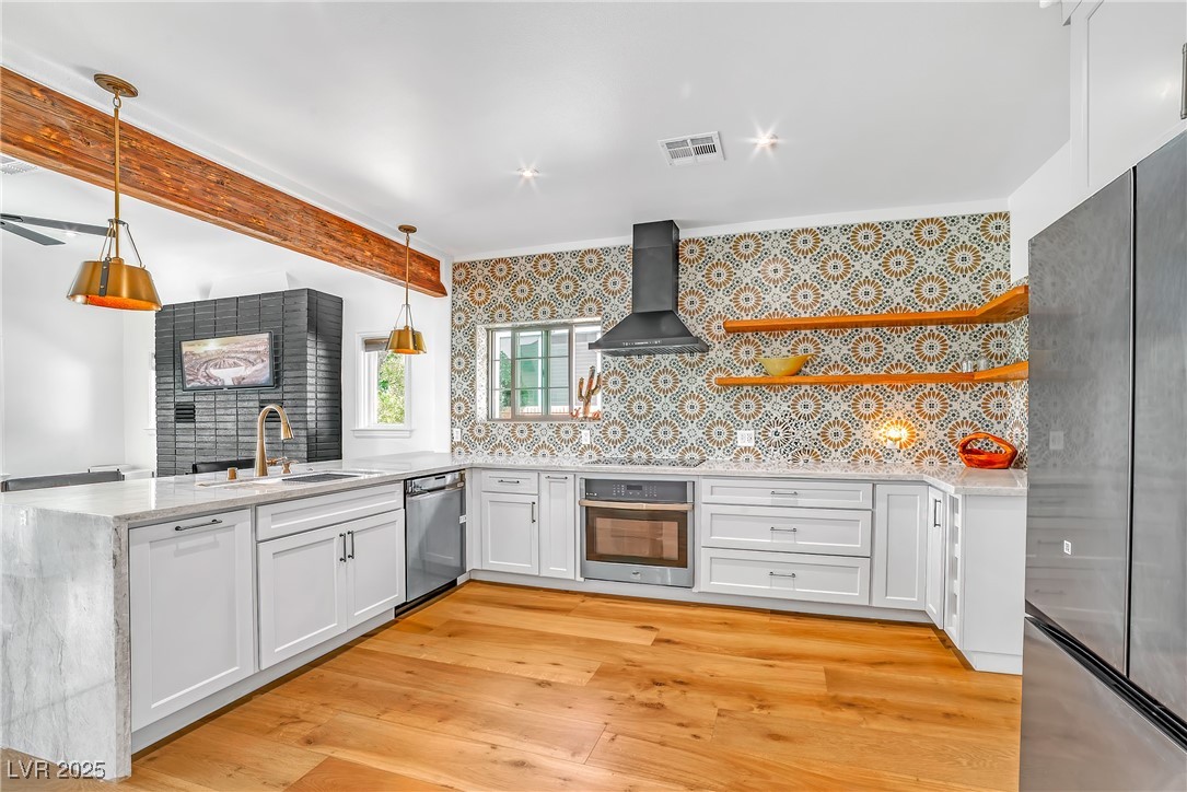 1318 Denver Street Boulder City, NV 89005 - Photo 3 of 32 Chef's Kitchen with a peninsula, custom counters, mosaic tile backsplash wall, and stainless steel appliances