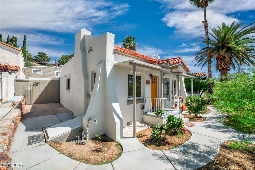 1318 Denver Street Boulder City, NV 89005 - Photo 31 of 32 View of front facade featuring stucco siding, a porch, and a chimney