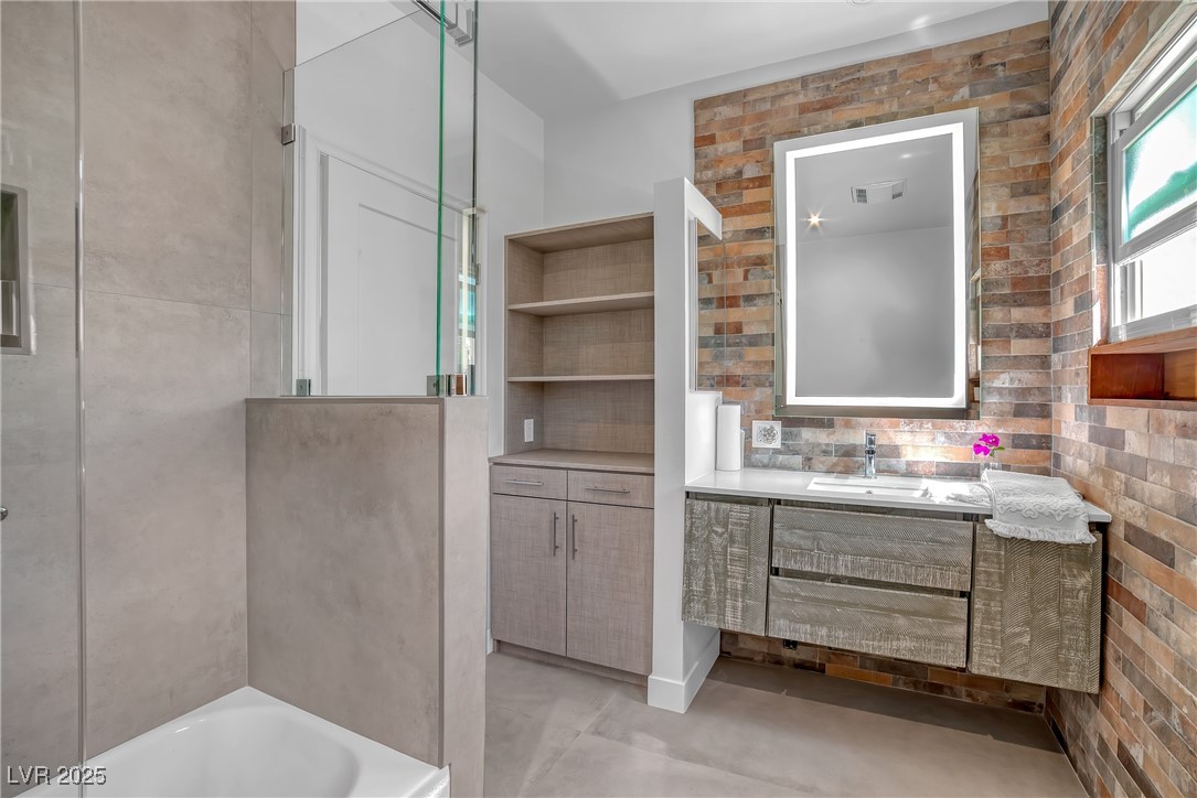 1318 Denver Street Boulder City, NV 89005 - Photo 7 of 32 Full bathroom with floating vanity, smart mirror and brick walls