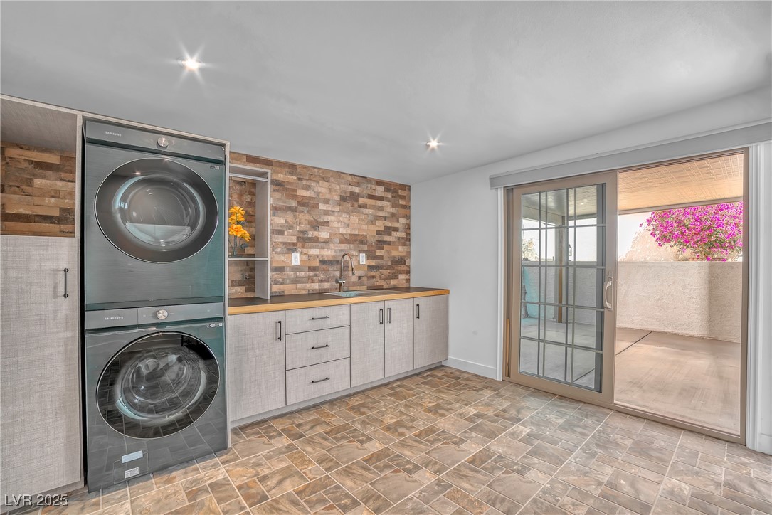1318 Denver Street Boulder City, NV 89005 - Photo 9 of 32 Washroom with stacked washing machine and dryer and stone finish walls and tile floors.