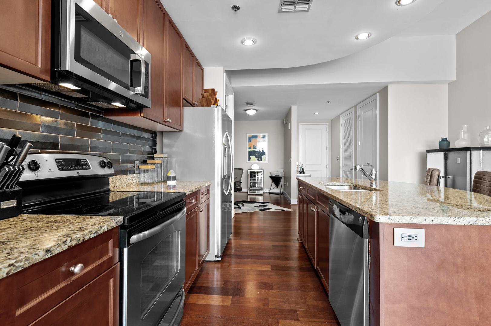 301 Fayetteville Street, Unit 33111 Raleigh, NC 27601 - Photo 13 of 64 a kitchen with stainless steel appliances granite countertop a stove a sink and a microwave