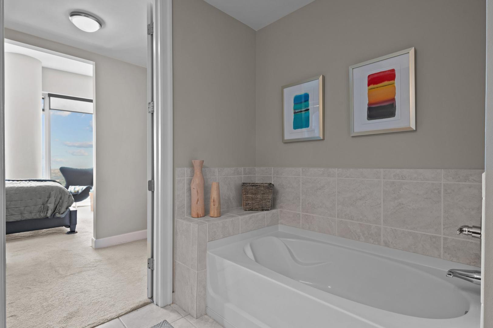 301 Fayetteville Street, Unit 33111 Raleigh, NC 27601 - Photo 23 of 64 a white bath tub sitting next to a small bathroom