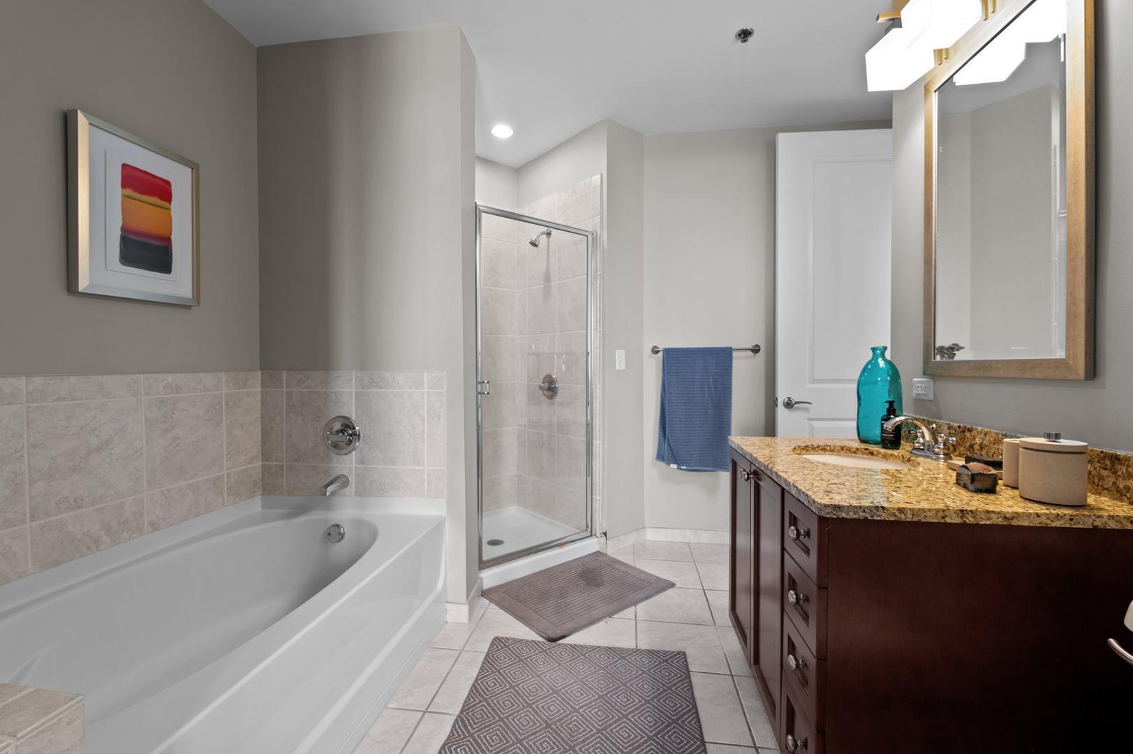 301 Fayetteville Street, Unit 33111 Raleigh, NC 27601 - Photo 26 of 64 a bathroom with a tub sink and mirror