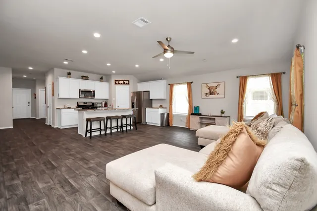 a living room with furniture and kitchen view