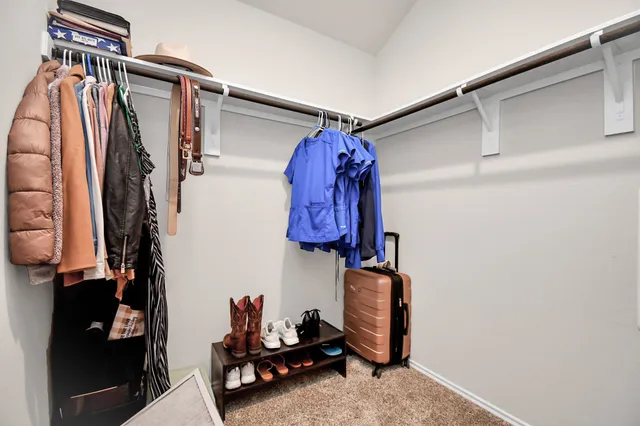 a view of walk in closet with clothes and shoes