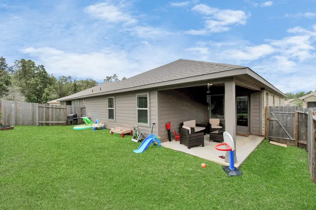 a view of a backyard with a sitting area and wooden fence