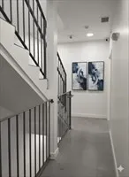 a view of staircase with lots of frames on wall and a painting