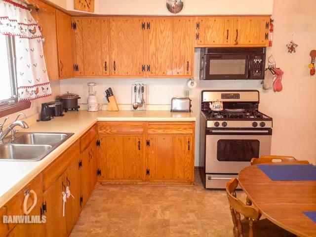 12289 Tresemer Road Roscoe, IL 61073 - Photo 8 of 25 a kitchen with a stove a sink and a microwave