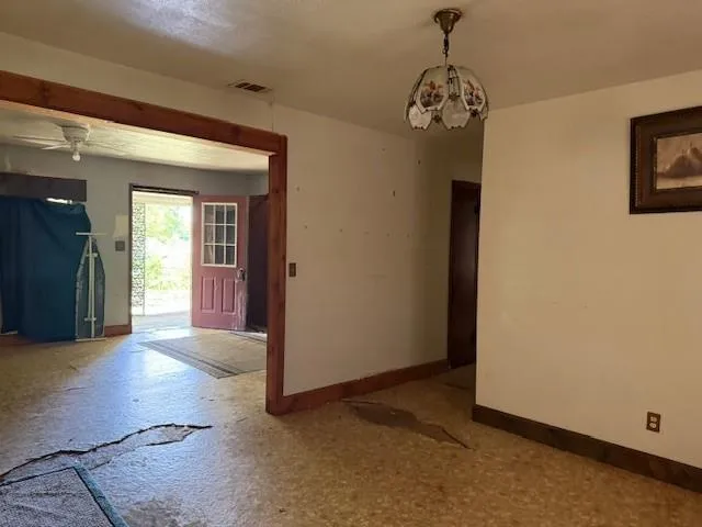 a view of a hallway with windows and chandelier