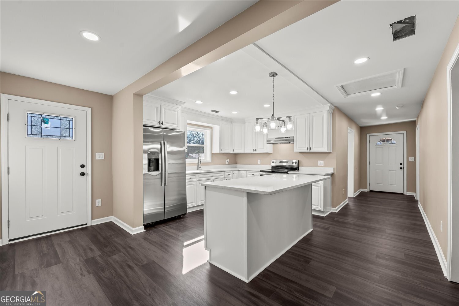 401 Baltimore Road Washington, GA 30673 - Photo 12 of 22 a large kitchen with a center island wooden floor stainless steel appliances and a window