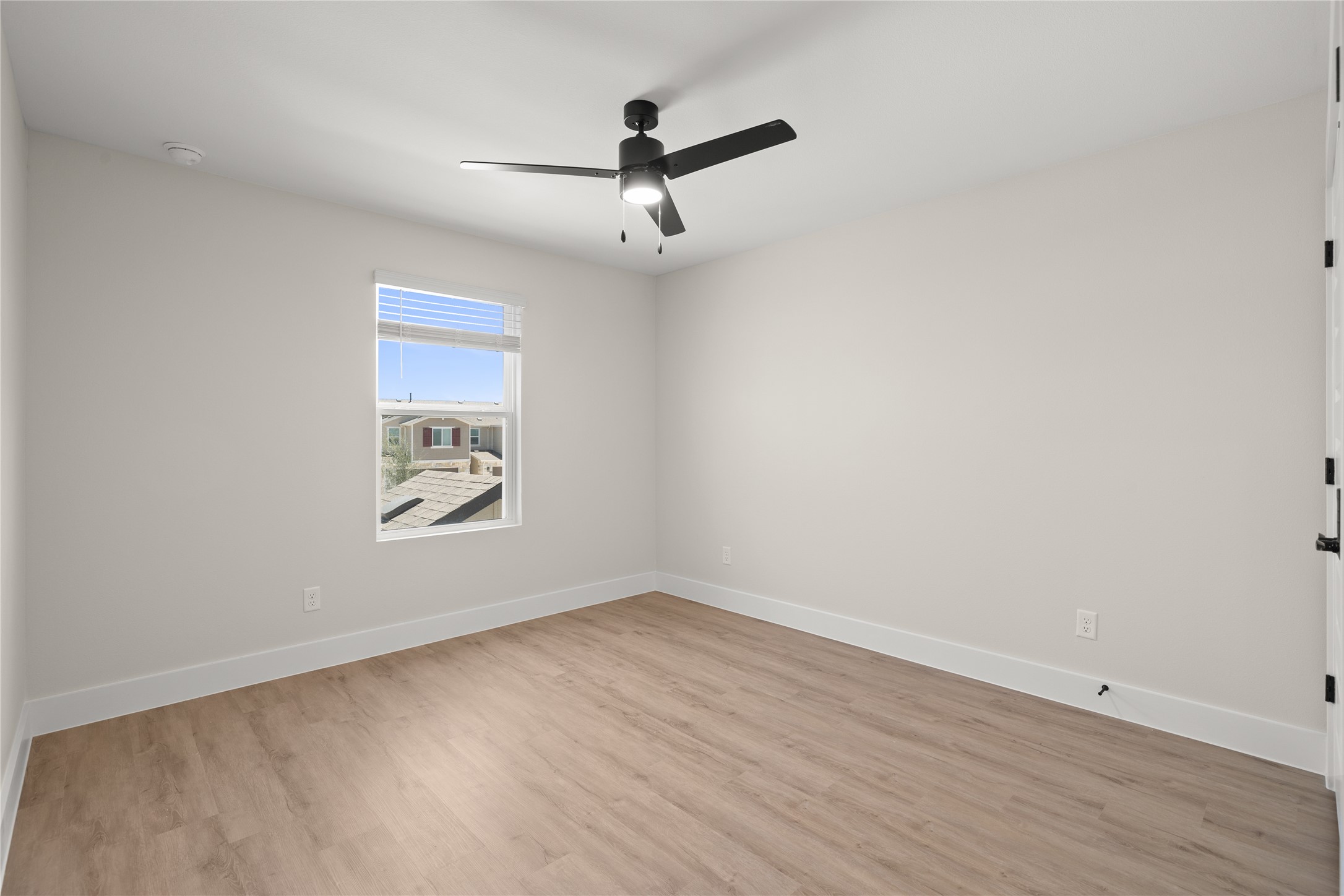 5514 Mobeetie Loop Bee Cave, TX 78738 - Photo 12 of 20 an empty room with wooden floor ceiling fan and windows