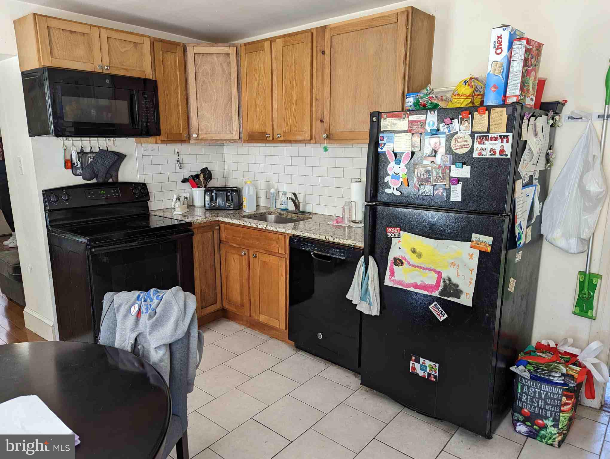 7101 Ridge Avenue Philadelphia, PA 19128 - Photo 10 of 19 a kitchen with granite countertop a refrigerator and a stove top oven