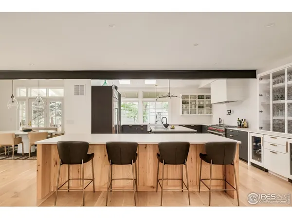 a kitchen with stainless steel appliances a table and chairs in it