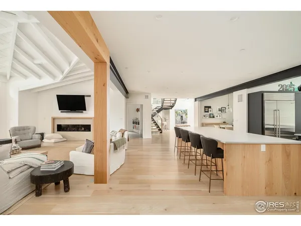 a living room with furniture flat screen tv and view of kitchen