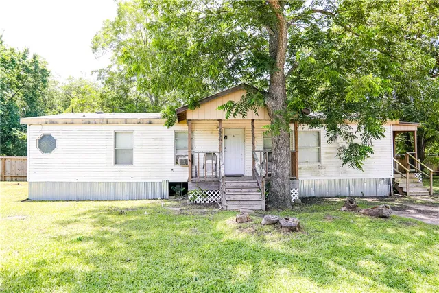 a view of a house with a backyard and a tree