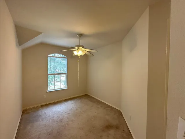 an empty room with windows and chandelier