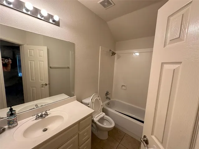 a bathroom with a sink a toilet a mirror and shower