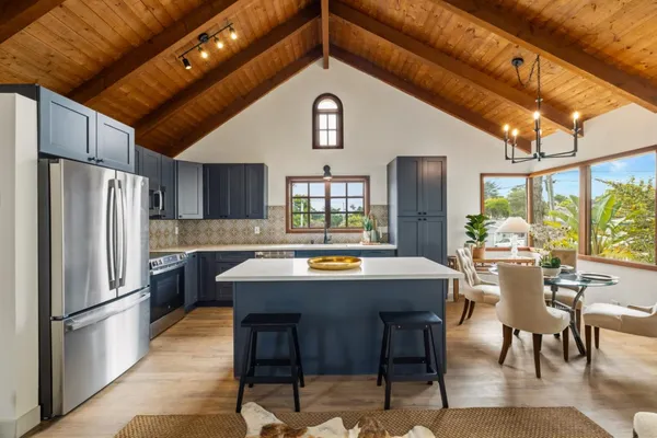 a kitchen with stainless steel appliances a table chairs and a refrigerator