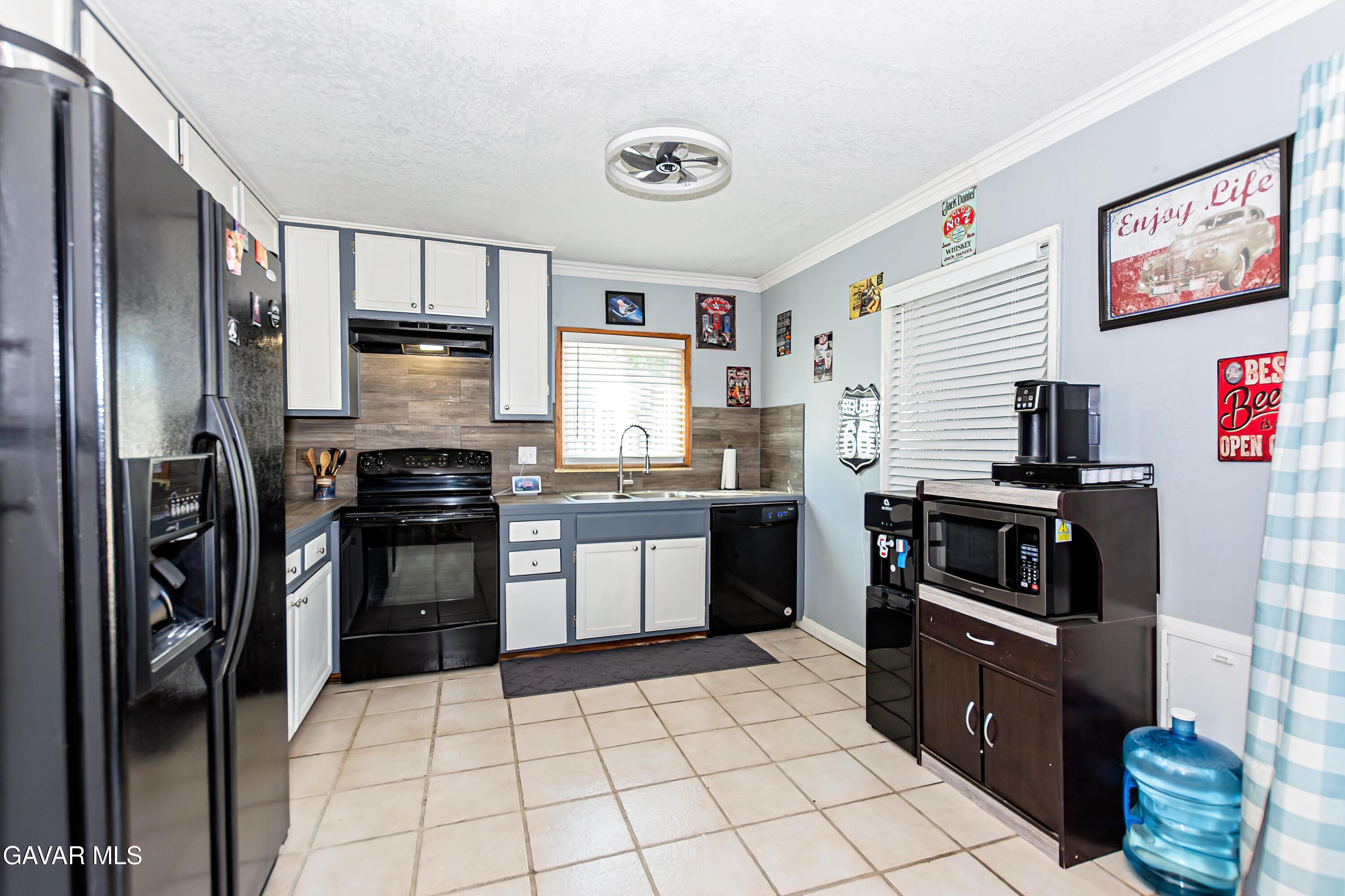 42933 Alexo Drive Lancaster, CA 93536 - Photo 12 of 32 a kitchen with granite countertop a refrigerator and a stove top oven