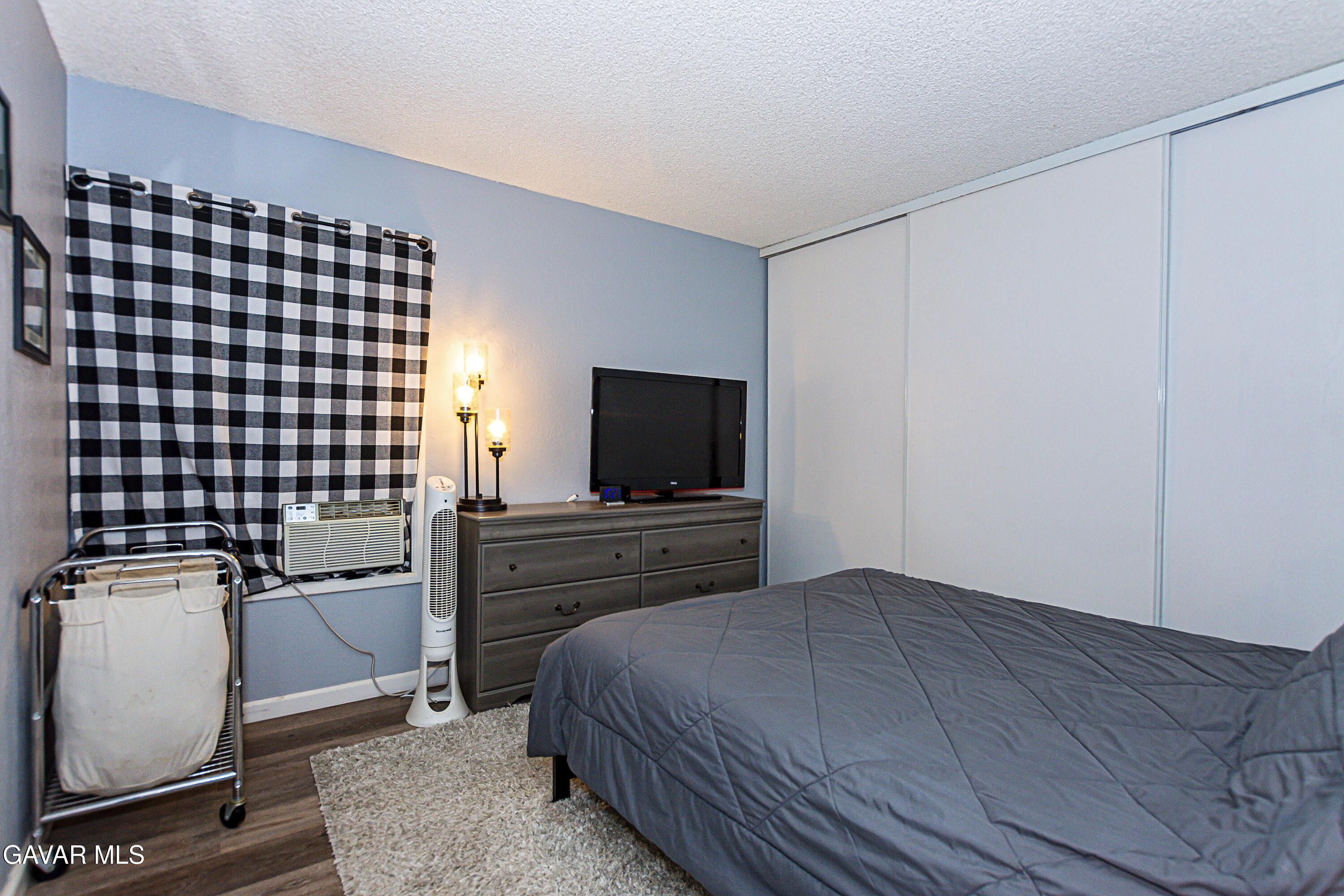 42933 Alexo Drive Lancaster, CA 93536 - Photo 19 of 32 a bedroom with a bed and a flat screen tv