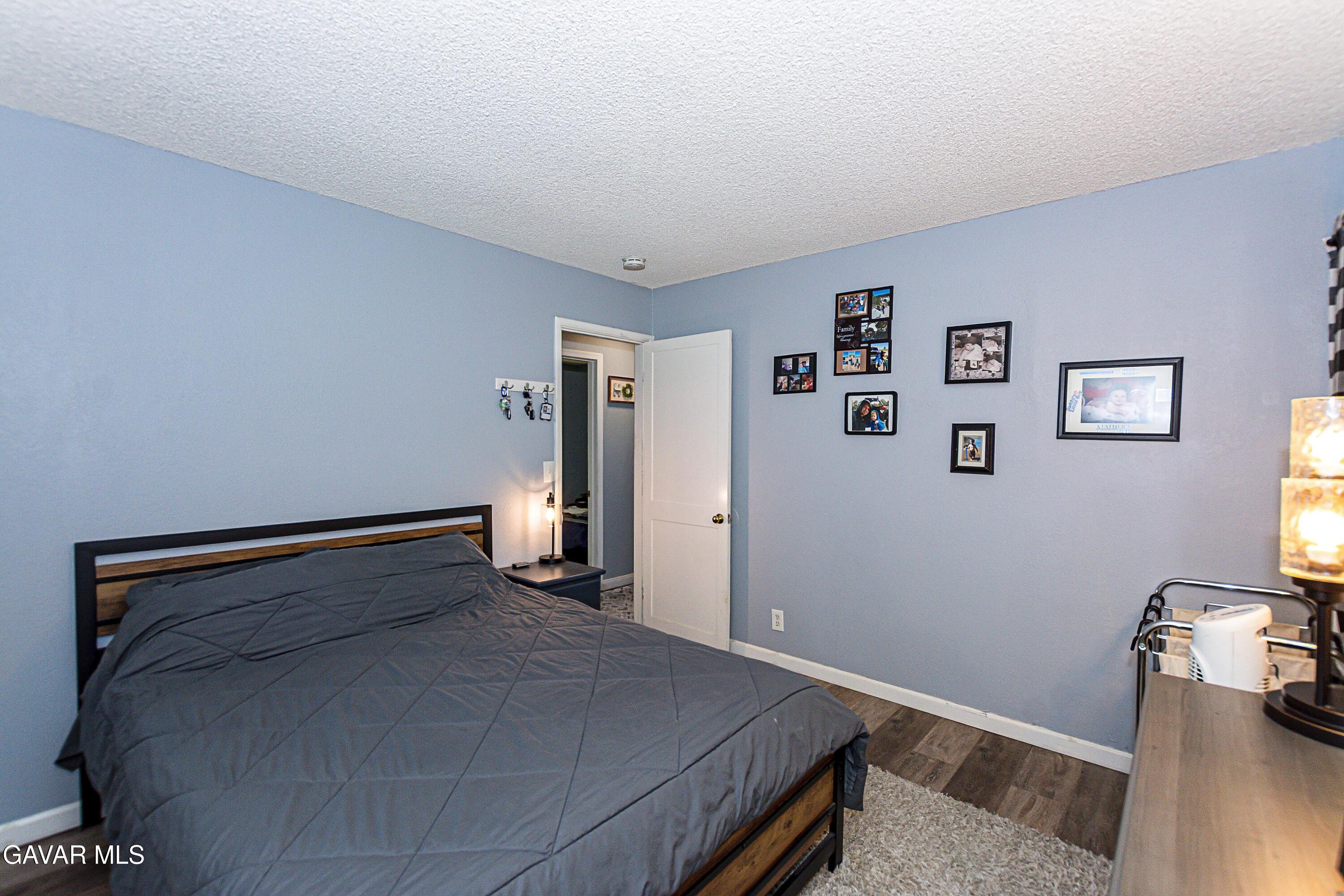 42933 Alexo Drive Lancaster, CA 93536 - Photo 21 of 32 a bedroom with a bed and wooden floor