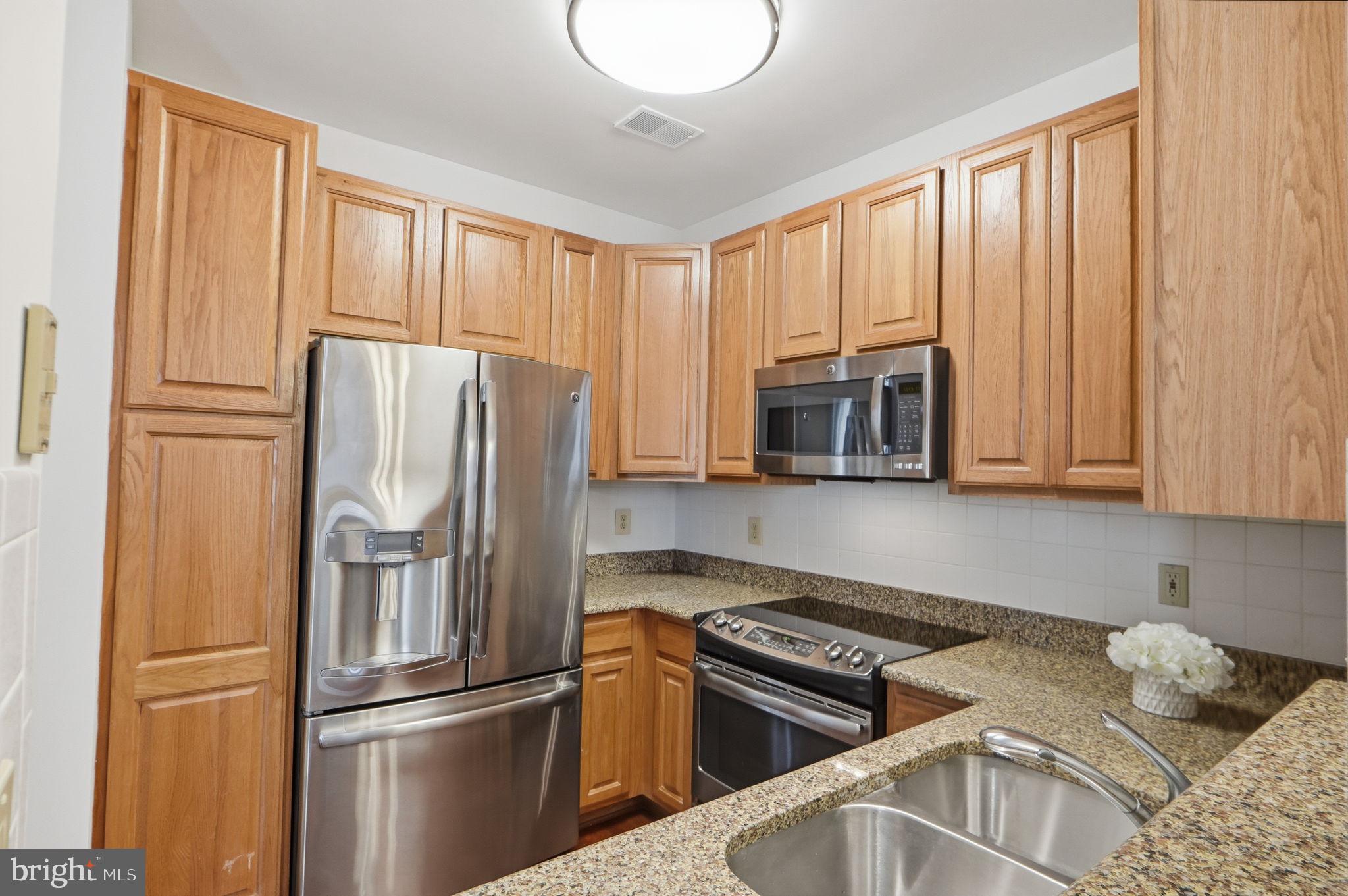 7023 Haycock Road Falls Church, VA 22043 - Photo 11 of 22 a kitchen with stainless steel appliances granite countertop a refrigerator sink and cabinets