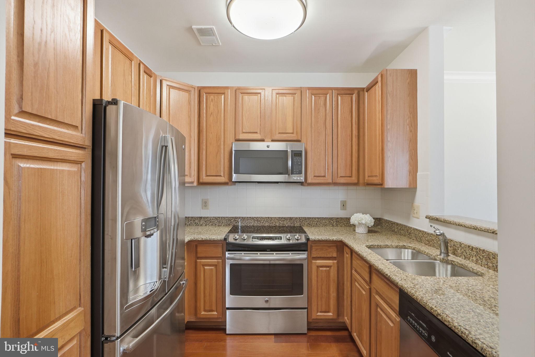 7023 Haycock Road Falls Church, VA 22043 - Photo 12 of 22 a kitchen with granite countertop a refrigerator stove and sink