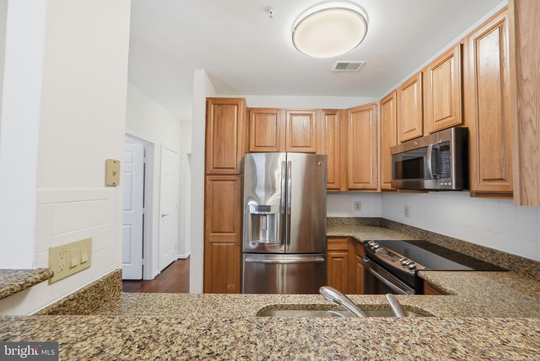 7023 Haycock Road Falls Church, VA 22043 - Photo 10 of 22 a kitchen with stainless steel appliances granite countertop a refrigerator stove top oven and sink