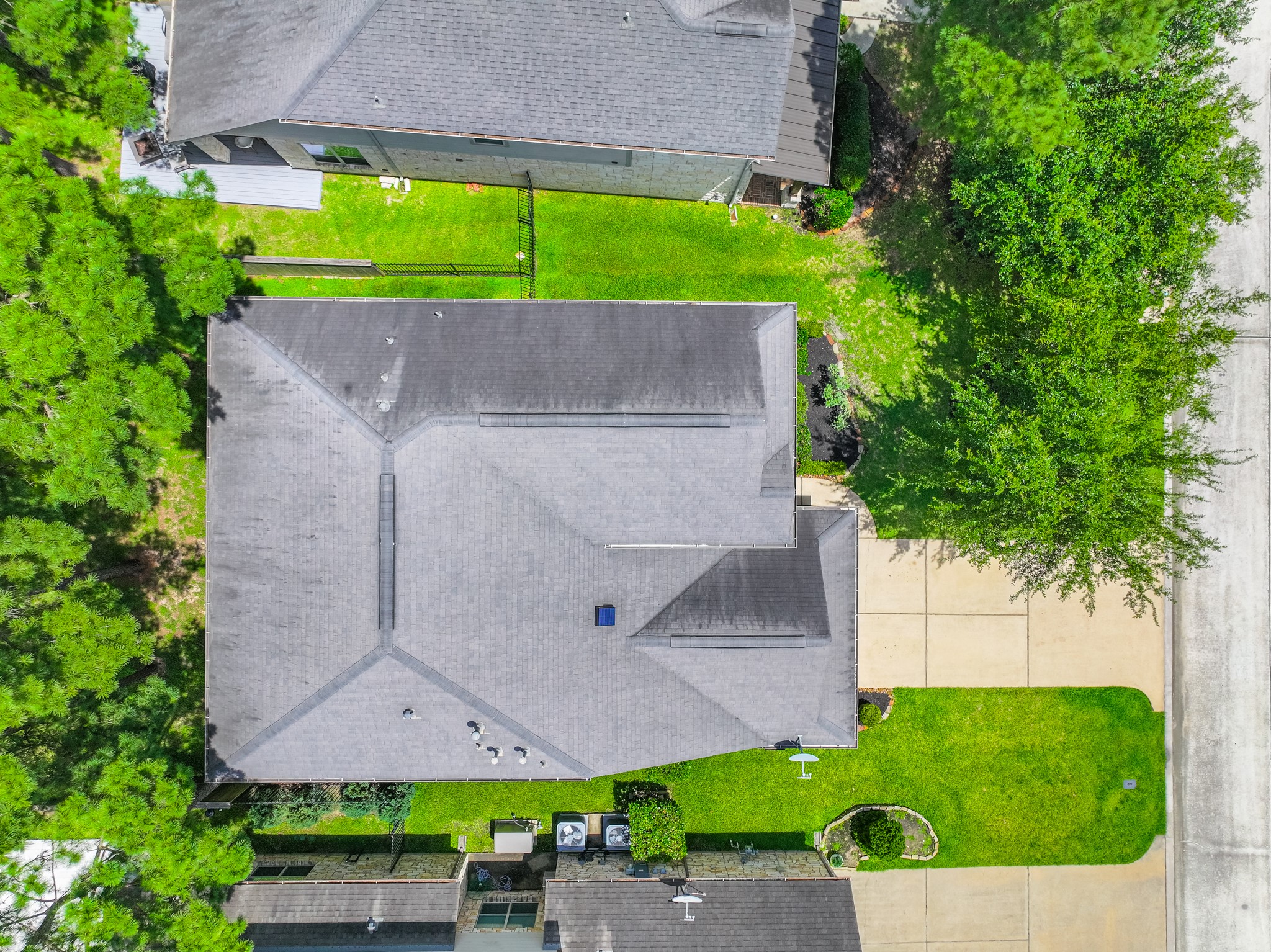 79 West Jagged Ridge Circle Spring, TX 77389 - Photo 48 of 50 This top-down aerial view showcases the home's rooftop, driveway, and the large shade tree out front, offering a unique perspective on the property's layout and setting. It's a great way to visualize the lot and how the home sits within it.