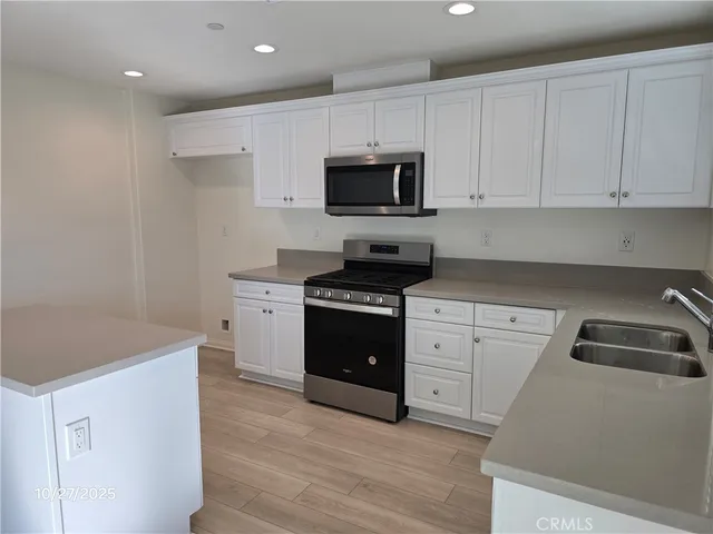 a kitchen with white cabinets and appliances