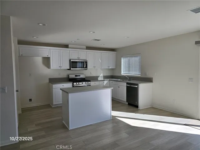 a kitchen with granite countertop a refrigerator and a stove top oven