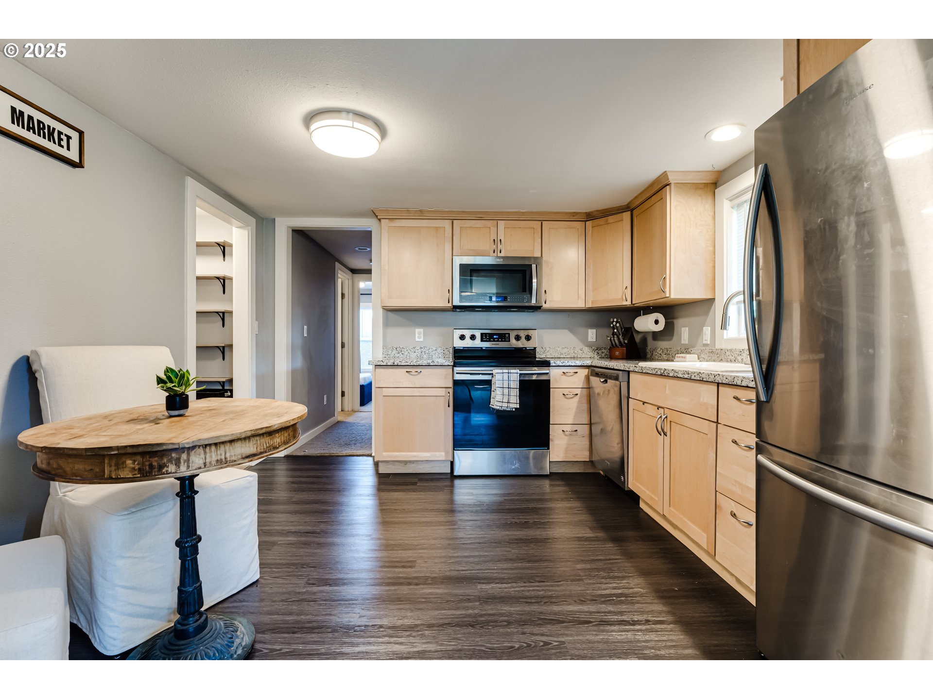 320 26th Street Springfield, OR 97477 - Photo 4 of 24 a kitchen with stainless steel appliances kitchen island granite countertop a refrigerator a sink dishwasher a stove with dining table and chairs