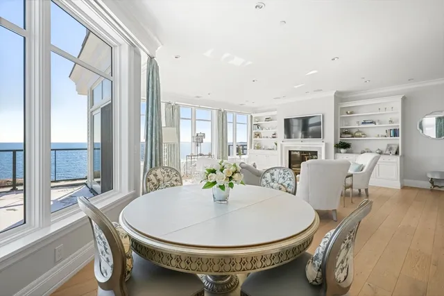 a spacious bedroom with a bed chandelier and windows