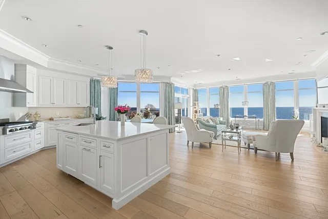 a kitchen with stainless steel appliances granite countertop a stove a sink dishwasher a dining table and chairs with wooden floor