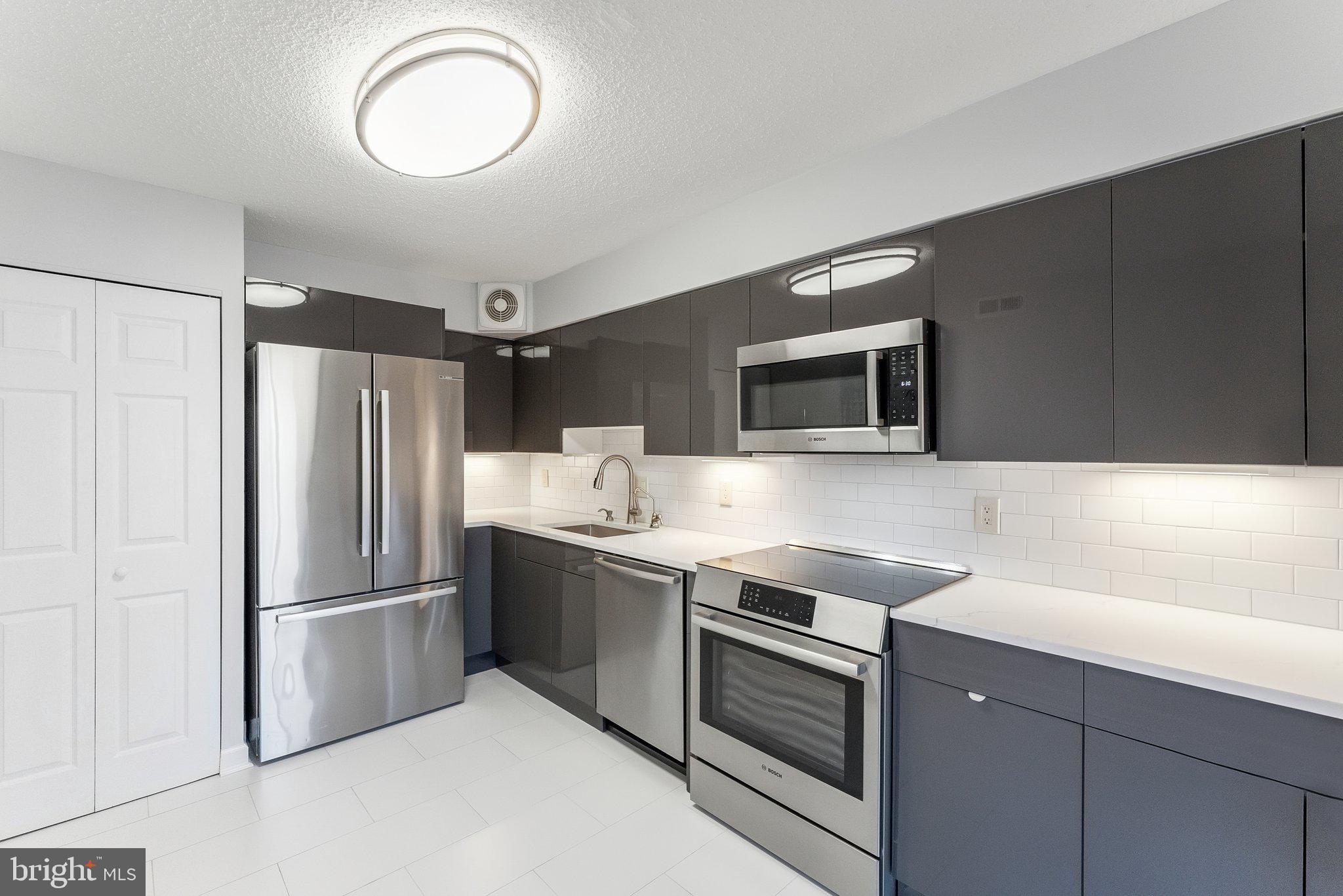 1077 30th Street Northwest, Unit 705 Washington, DC 20007 - Photo 13 of 31 a kitchen with stainless steel appliances granite countertop a refrigerator and a sink