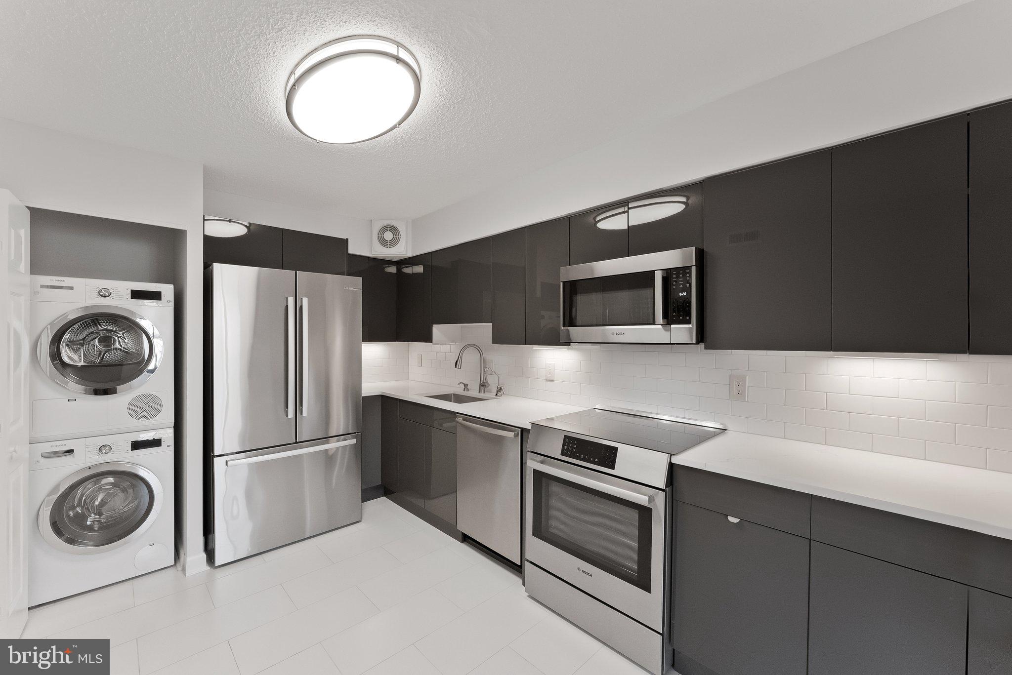 1077 30th Street Northwest, Unit 705 Washington, DC 20007 - Photo 14 of 31 a kitchen with stainless steel appliances granite countertop a refrigerator and a stove top oven