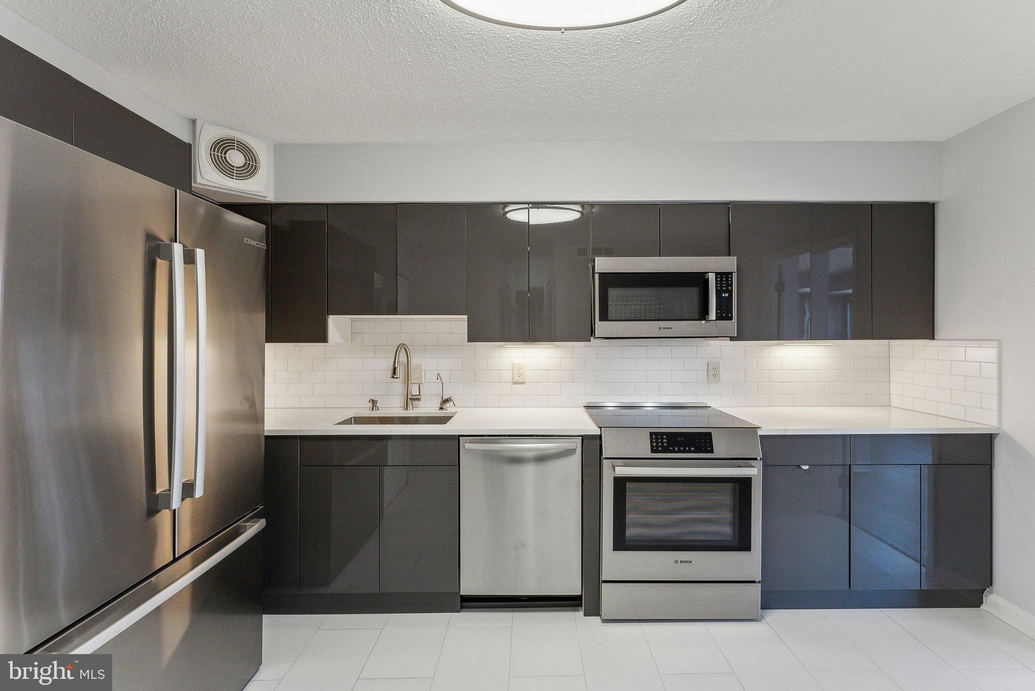 1077 30th Street Northwest, Unit 705 Washington, DC 20007 - Photo 15 of 31 a kitchen with stainless steel appliances a stove a sink and a refrigerator