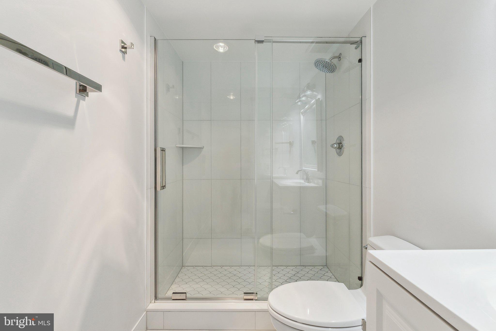 1077 30th Street Northwest, Unit 705 Washington, DC 20007 - Photo 20 of 31 a bathroom with a shower a toilet and a sink