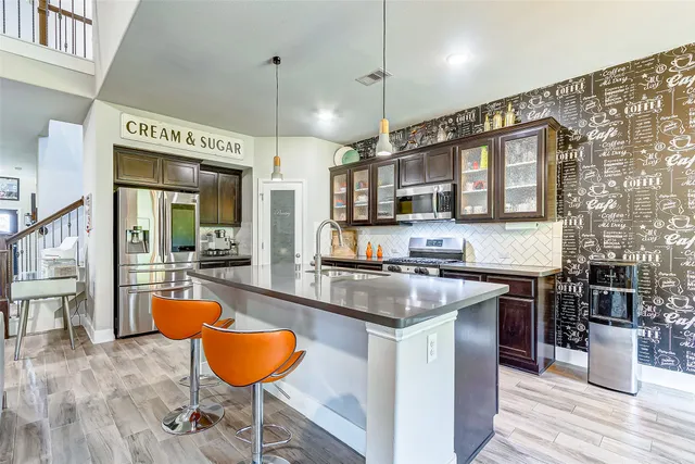 a kitchen with stainless steel appliances granite countertop a stove refrigerator and cabinets