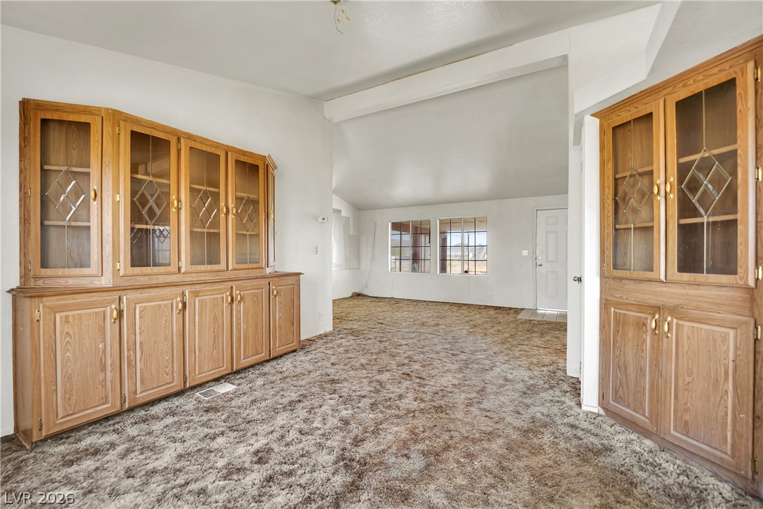 4361 Maple Road Pahrump, NV 89048 - Photo 9 of 46 A spacious interior with abundant natural light, offering a versatile layout with a cozy, carpeted floor.