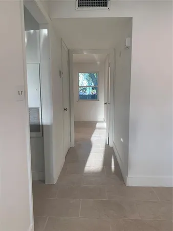 a view of a hallway with wooden floor and glass door