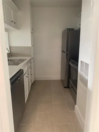 a kitchen with granite countertop a refrigerator and a stove